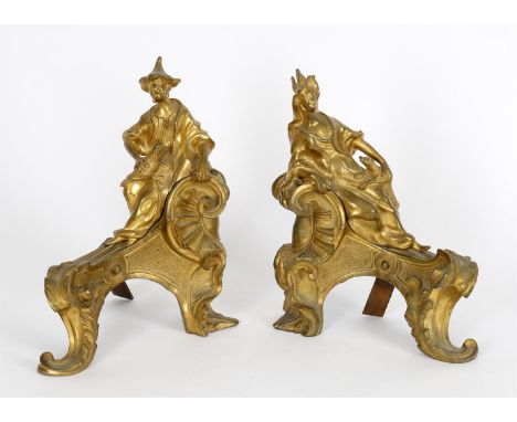
	
		A pair of ormolu chenets in Louis XV Chinoiserie taste, modelled opposing, one as a man seated on a 'C' scroll holding a