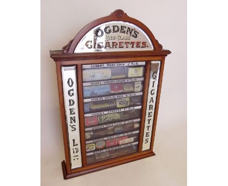 An Ogden's High Class Cigarettes shop display vending cabinet with mirrored arch top and side panels, each shelf with painted