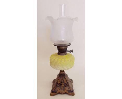 A Victorian oil lamp with cast metal base, yellow opaque glass reservoir (cracked ) and etched glass opaque shade