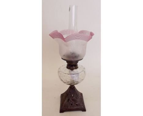 A Victorian oil lamp with cast metal base decorated stork, clear glass reservoir and etched and cranberry reeded shade, Duple