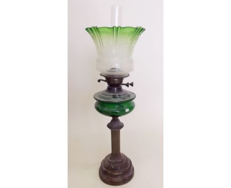 A Victorian brass column form oil lamp with green glass reservoir and green etched shade
