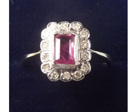 A 9 carat gold ring set emerald cut ruby within diamond surround - size M1/2