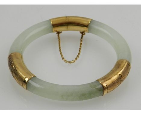 A Chinese yellow metal mounted pale green jade bangle. D: 7cm