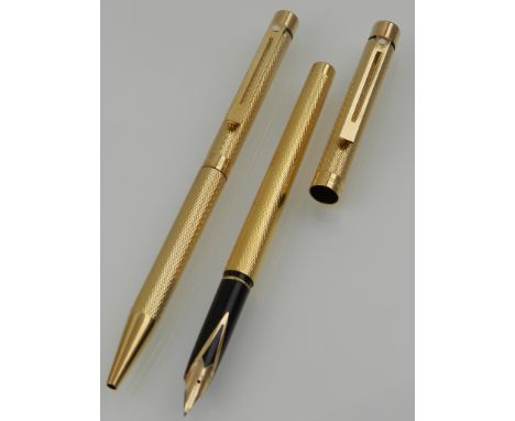 A cased set of a Sheaffer gold plated fountain and ball point pen, having engine turned design.
