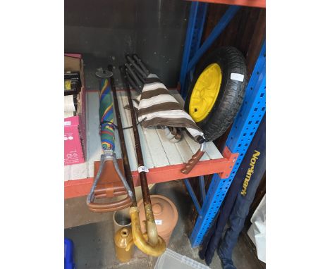 A wheelbarrow spare wheel, a shooting stick umbrella, a walking stick chair and 2 horn handled walking sticks. 