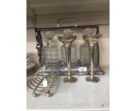 A chrome tantalus with three decanters, a pair of plated vases, and a silver plated toast rackThe tantalus has no marks.