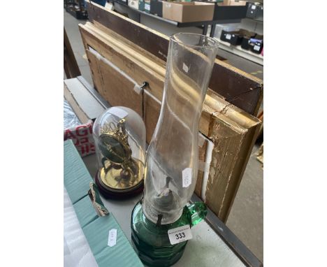 A vintage Schatz under perspex dome mantel clock, made in Germany - AF and a green glass paraffin lamp with funnel. 