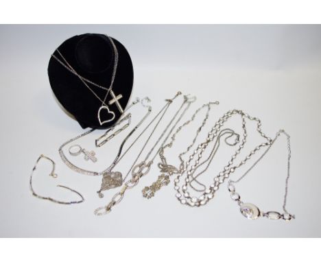 A Swarovski cross and chain, the cross set with white stones, another cross; a Swarovski heart shaped pendant and chain; a Sw