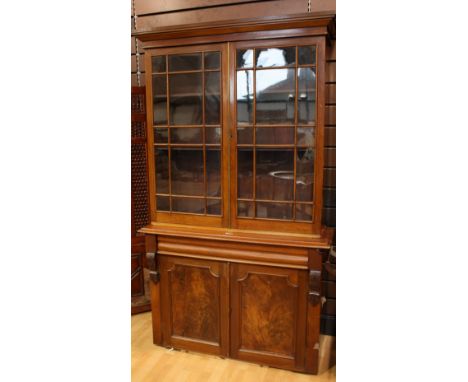 A Victorian mahogany library bookcase, outswept cornice above a pair of glazed doors enclosing two shelves, the projecting ba