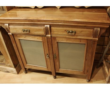 A 20th century sideboard, oversailing rectangular top above a pair of frieze drawers and two glazed doors enclosing a shelf