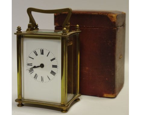 An early 20th century French brass carriage clock, white enamel dial, black Roman numerals, with associated maroon Moroccan l