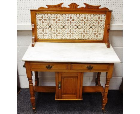 An earl 20th century tile back wash stand, marble top over two short drawer and cupboard, turned legs ceramic casters