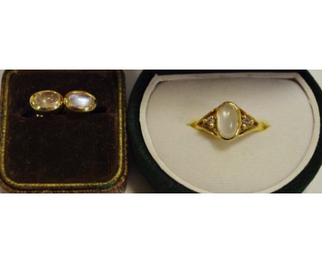 An 18ct gold ring set with a moonstone flanked by two white sapphires, size Q; a pair of conforming 18ct gold earrings, both 