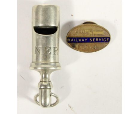 An N.E.R metal whistle and an oval L.N.E.R railway service button hole badge