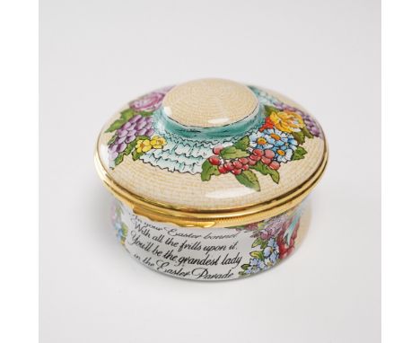 Decorative round enameled music box by Halcyon Days, finely detailed with a colorful Easter bonnet motif surrounded by spring