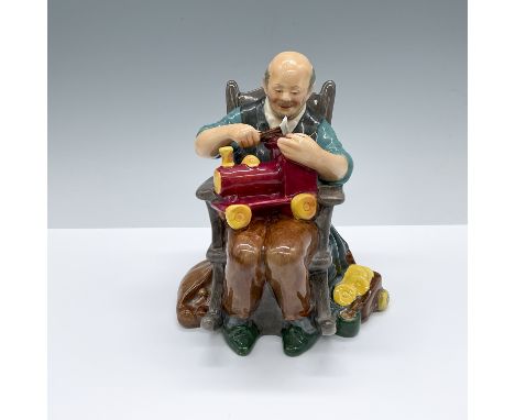 hand decorated figure of a seated man building a toy train. Royal Doulton backstamp.Artist: M. NicollIssued: 1959-1973Dimensi