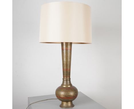 Brass table lamp featuring a tall baluster form and bulbous base, finely engraved with intricate floral and foliate motifs. A