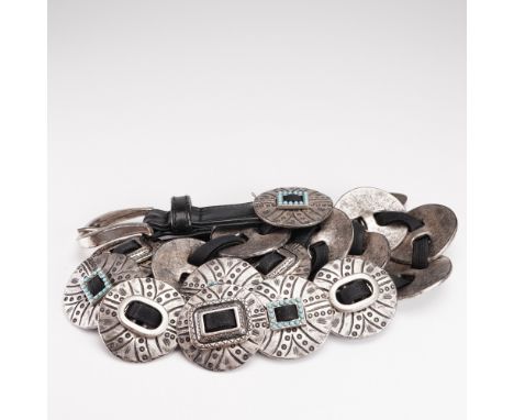 A designer concho belt by Suzi Roher of Canada, featuring a series of circular silver-tone metal conchos joined by elastic ba