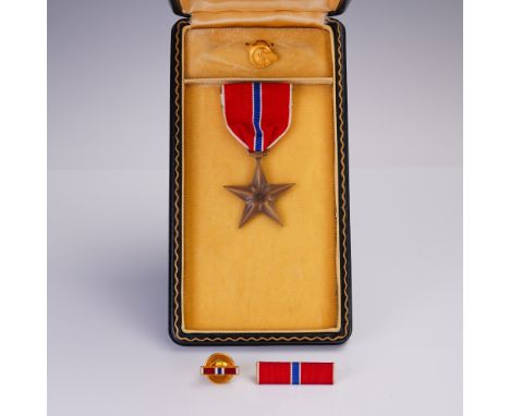 A distinguished Bronze Star medal set comprising four pieces: the full-size medal with ribbon, a service bar, an enamel ribbo