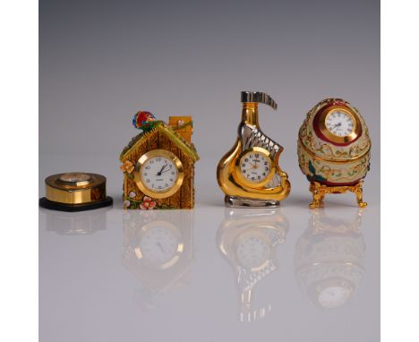 Group of four miniature decorative clocks, including a birdhouse with enameled flowers and jeweled parrot, a gold and silver 
