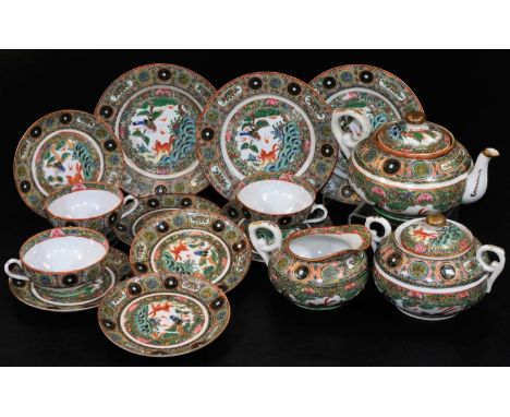 A Cantonese porcelain part tea service, comprising squat teapot, 13cm H, milk jug, two handled sugar bowls, cups, plates and 