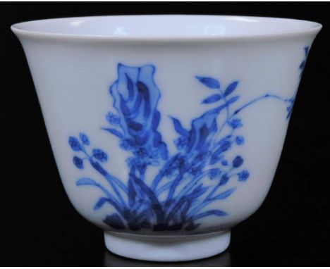 A Chinese porcelain blue and white month cup, with six character Kangxi mark, decorated with orchids emerging from rocks and 