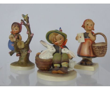 Two West German Goebel Figurines, including girl with a basket, boy with rabbits and girl in a blossom tree. (3)