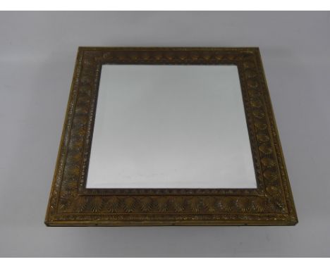 An Edwardian Arts and Crafts Mirror, the mirror having bevelled glass with brass frame depicting delicate shell motif, approx