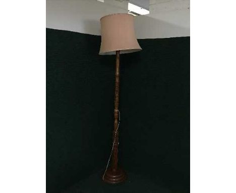 A heavily carved mahogany standard lamp and shade 