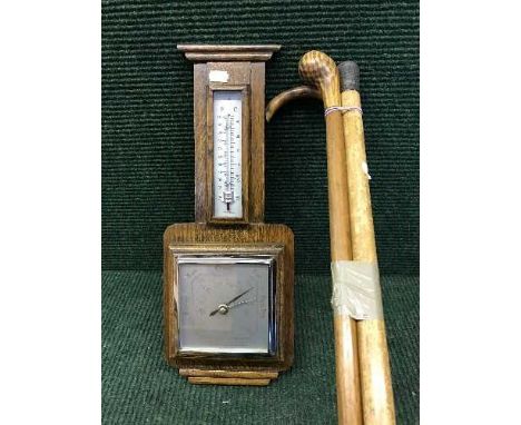 An early 20th century barometer and bundle of three walking sticks 