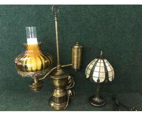 A metal table lamp in the form of an oil lamp, Tiffany style table lamp and two others 