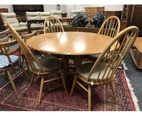 An Ercol light elm circular pedestal dining table and four Quaker Windsor chairs