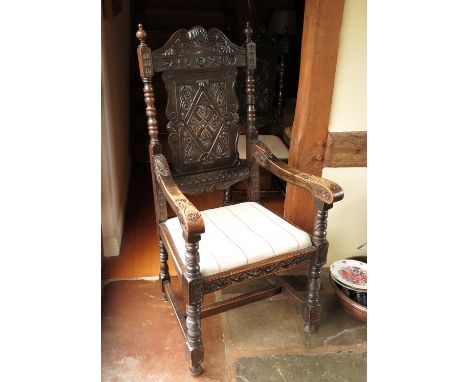 A set of ten Jacobean oak dining chairs, with carved panel backs, dated 1625, eight standard and two carvers