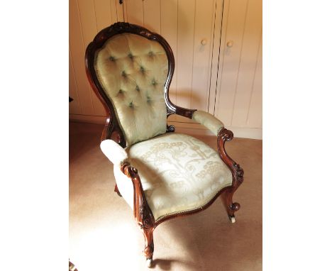A Victorian show wood mahogany grandfather's chair, with part carved frame raised on front scroll legs and button back