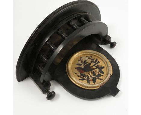 An Edwardian Aesthetic style ebonised wall bracket, the curved top with turned spindles below, set with a circular gilt frame