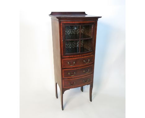 An Edwardian mahogany bow front cabinet, with glazed door revealing a shelf over three drawers, raised on shaped legs, the wh