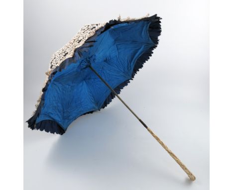 A 19th century lady's parasol, the carved ivory folding handle decorated with lily of the valley and leaves, the silk lined c