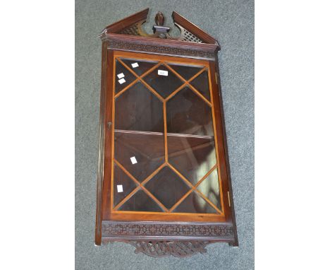 An Edwardian mahogany wall hanging corner display cabinet, fretworked architectural pediment with fluted urnular finial, blin