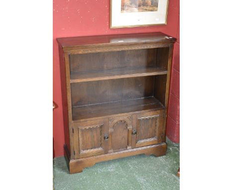 A small oak floor standing bookcase with adjustable shelf over two door cupboard. 103cm high x 84cm wide x 25.5cm deep.  