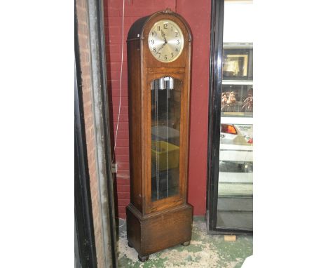 An oak cased longcase clock, by Enfield, domed top, silvered dial, Arabic numerals, glazed door to trunk, bun feet. C.1930/40