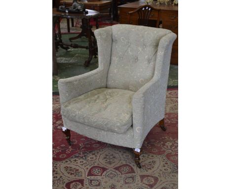 A late Victorian mahogany button upholstered wing back armchair, squab cushion, French cabriole legs, ceramic casters