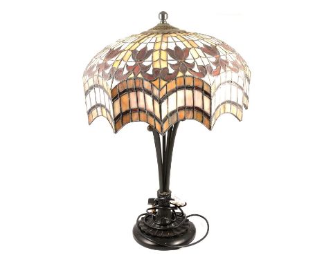 A Tiffany style table lamp, leaded glass shade, raised on a column in the form of a brazier, 62cm.