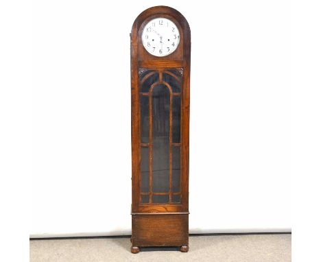 1940's oak longcase clock, domed top, glazed door, bun feet, ten inch circular silvered dial, the movement striking on eight 