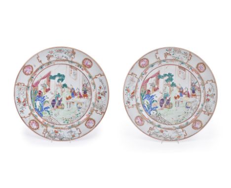 A large pair of Chinese Export Famille Rose chargers, Qianlong, painted with ladies and children in a fenced garden scene, 37