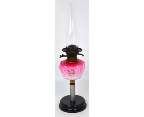 An oil lamp with painted pink font on rounded stepped ebonised base, height 61cm. CONDITION REPORT No chips or cracks to the 