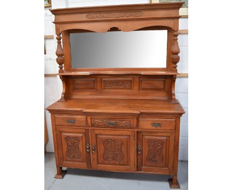 A large light oak sideboard, rectangular bevelled edge plate flanked by baluster style supports either side above three short