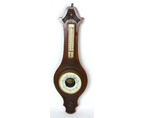 An oak wall barometer with carved floral decoration, height 57cm.