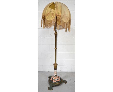 An early 20th century brass standard lamp with Oriental ceramic decoration to the base, on a stepped stand and Oriental curve