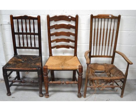 Three 19th century chairs to include a ladder back example with rush seat on turned stretchers and curving legs, an oak examp