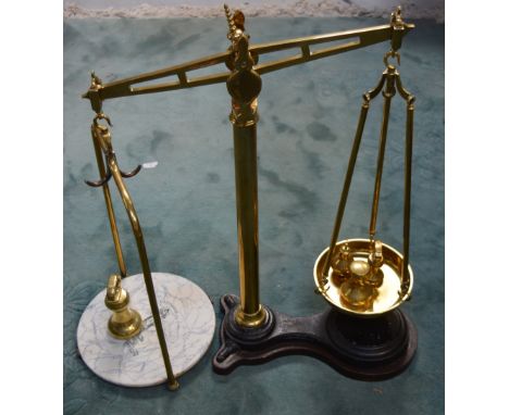 A large pair of brass W & T Avery Ltd of Birmingham scales on wooden base with accompanying weights.